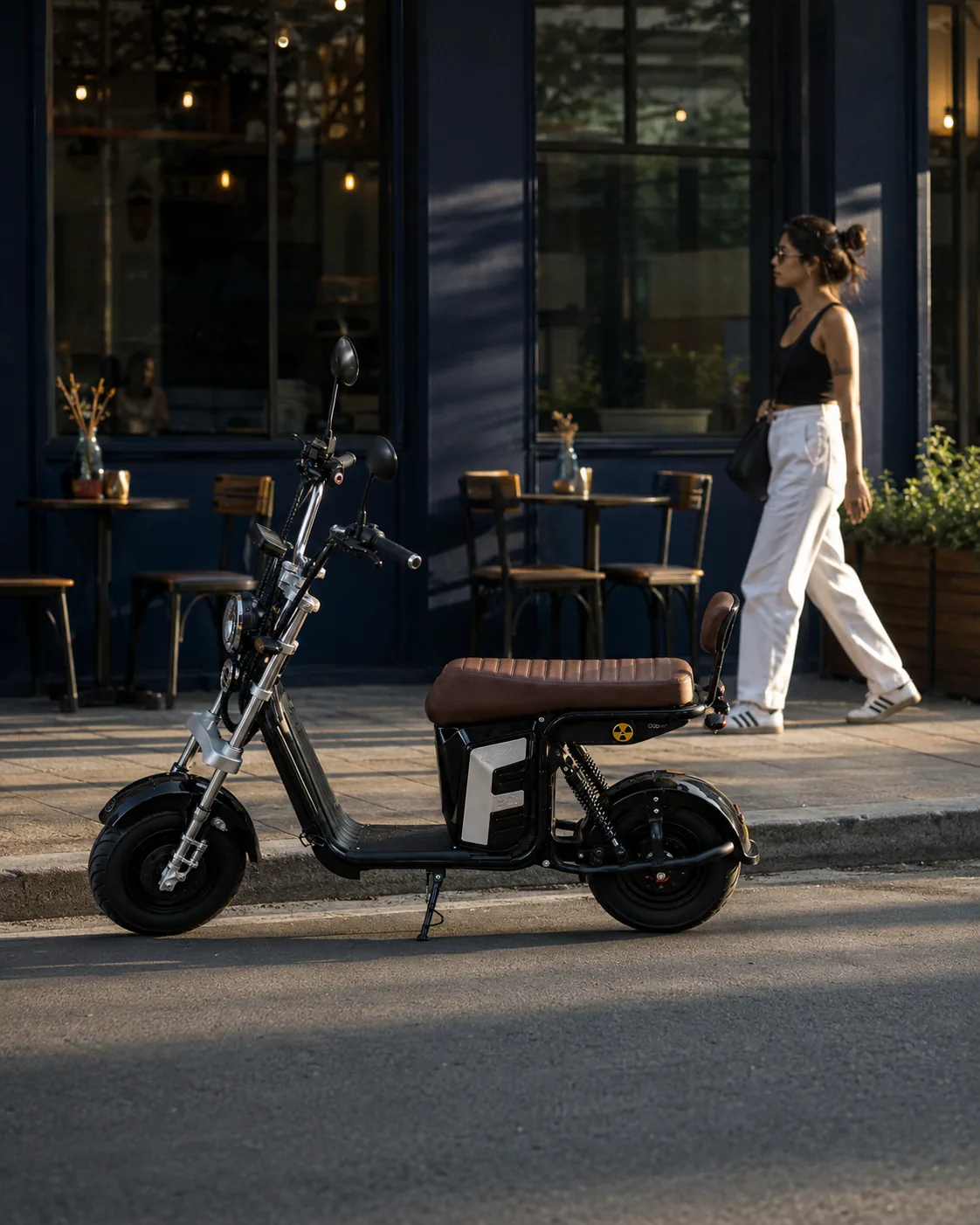 VYA Hard+ estacionada na calçada em frente a um café no fim da tarde