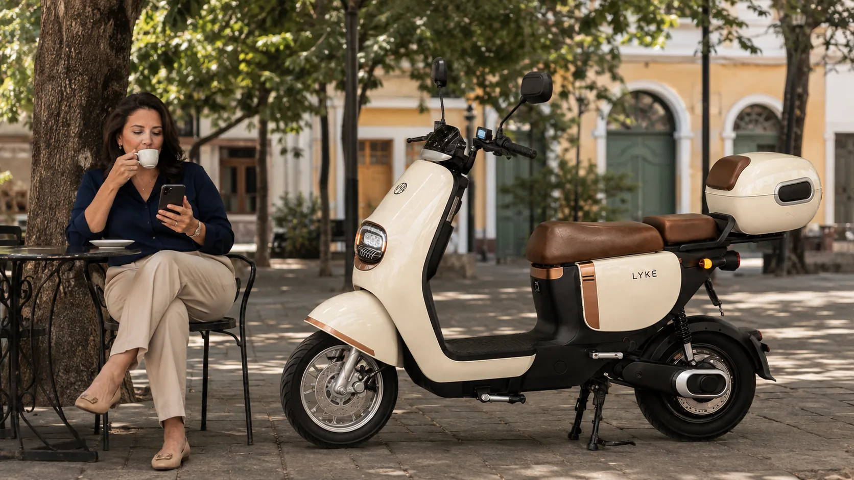 VYA Lyke estacionada na praça enquanto uma mulher toma café na mesa ao lado